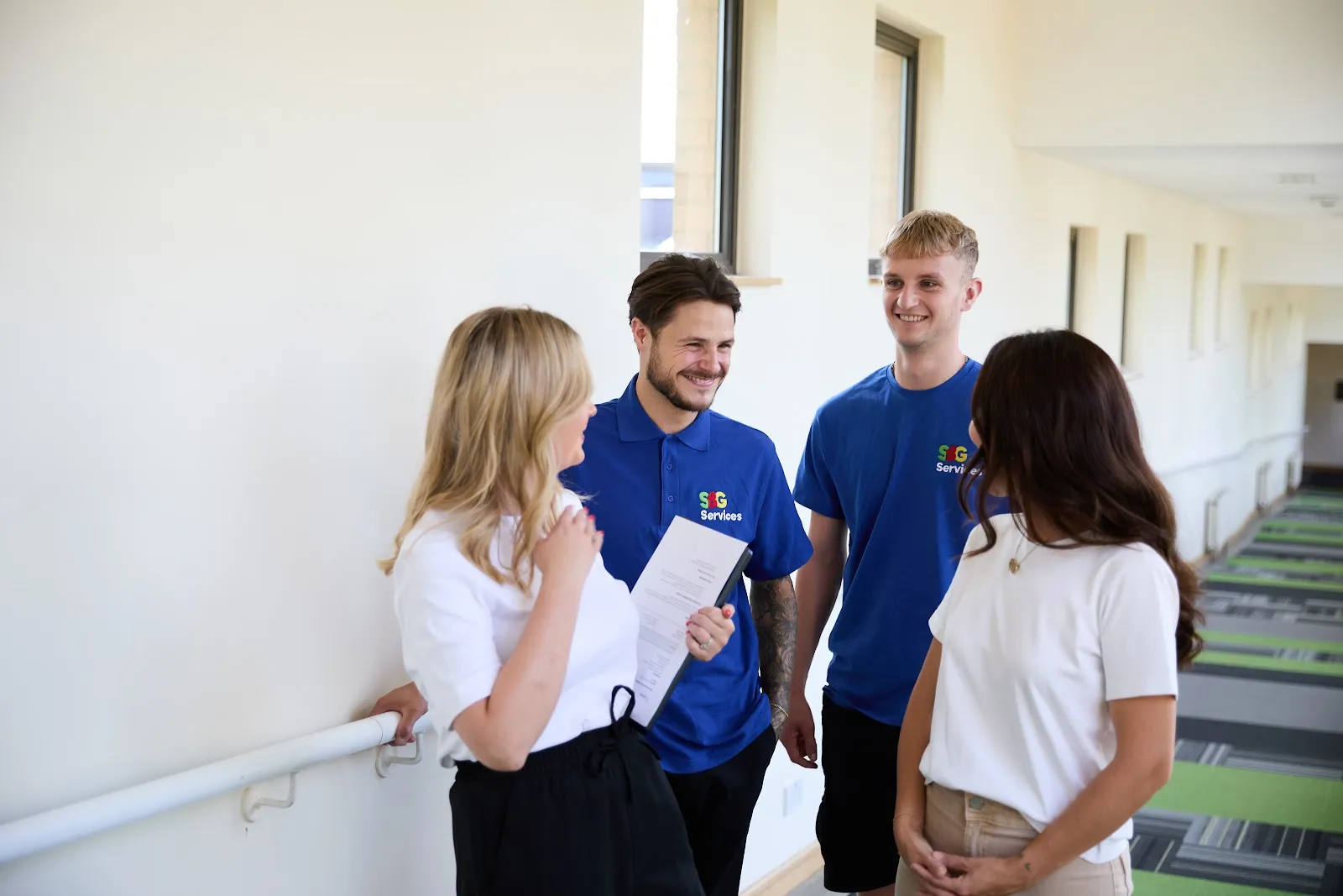 SBG Services managers and team members talking together in a corridor